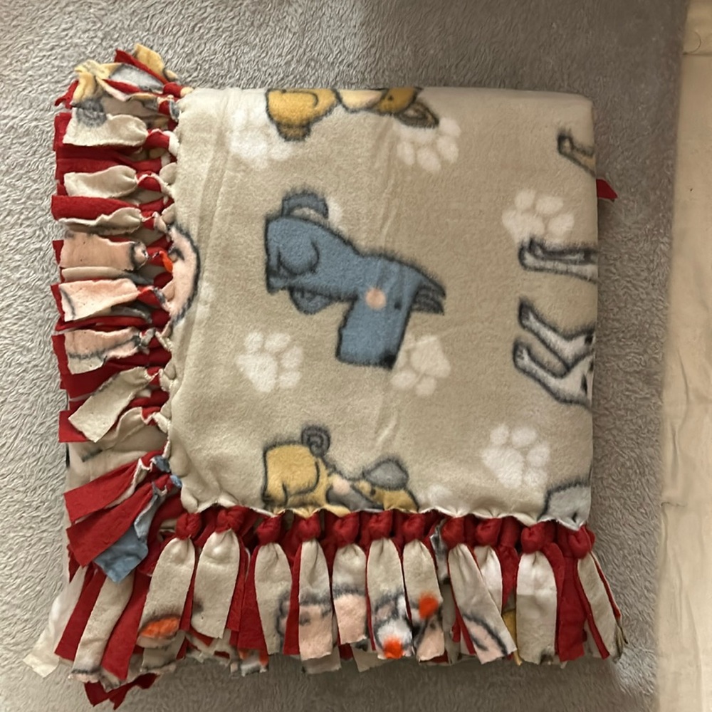 50x60” fleece tie blanket.  Puppy pattern fleece with red fleece backing